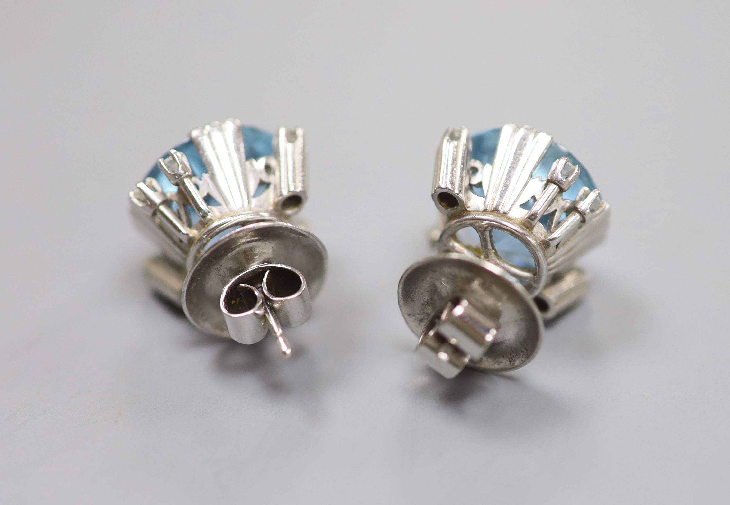 A modern pair of white metal, aquamarine and diamond set ear studs and a matching pendant